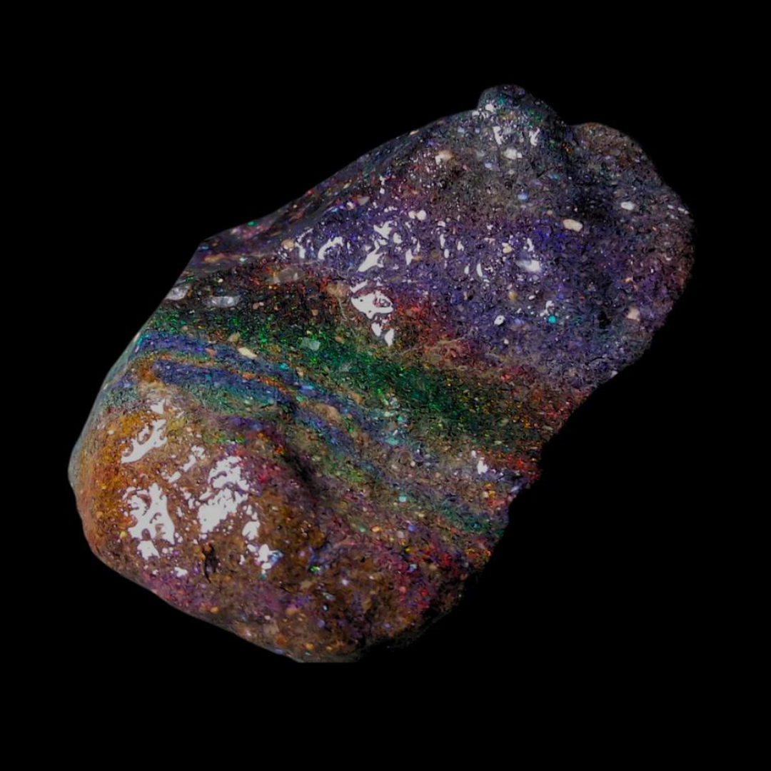 Honduras Opal mit einer dunklen, fast schwarzen Matrix und schimmernden Regenbogenfarben, die in verschiedenen Mustern durch den Stein verlaufen, auf schwarzem Hintergrund